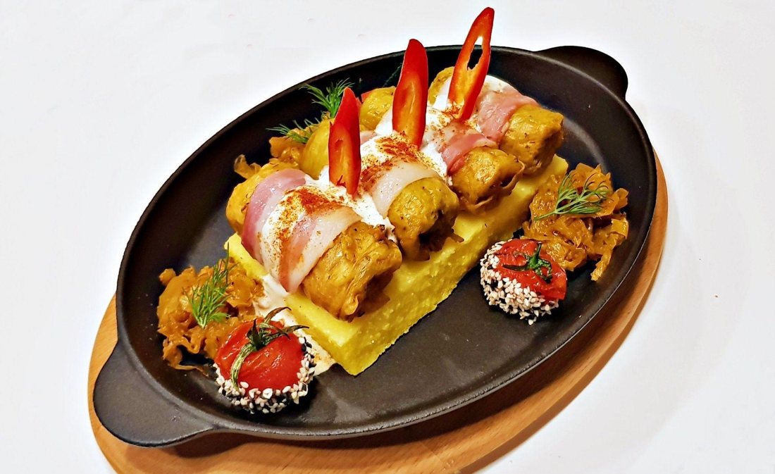 Romanian sarmale with polenta, sour cream and braised cabbage